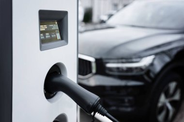 Elektrikli araba için EV şarj istasyonu, yeşil enerji kavramı, sürdürülebilir kaynaktan üretilen eko güç. Arabaya şarj gücü kablo pompası, modern teknoloji UI kontrol görüntüleme