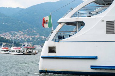 İtalyan gölünde tekne turu. Güneşli yaz gününde feribot hareket ediyor. Turist teknesi. Kamu motoru istasyona vardı veya istasyondan ayrıldı.