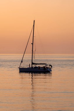 Tropea, İtalya - 17 Temmuz 2022: Yazın gün batımında yelkenli tekneli güzel deniz manzarası. Seyahat, hobi konsepti