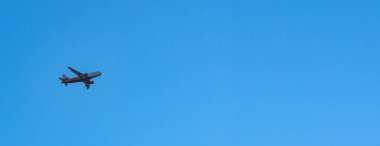 Mavi gökyüzünde uçan uçak. Hızlı seyahat, tatil ve iş kavramı.