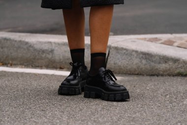 Milan, İtalya - 21 Eylül 2023: Kadın, Prada 'dan fırçalanmış deri ayakkabılar giyiyor, sokak tarzı aksesuarlar..