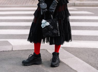 Milan, İtalya - 23 Şubat 2023: Prada Antika nappa marka deri mini çanta ve Moncler marka spor ayakkabı giyen kadın. Moda blogcusu kıyafet detayları, sokak tarzı