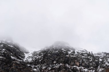 Dağ, kar ve sisle kaplı. İtalya 'da, Avrupa' da Alp manzarası. Mavi gökyüzüne karşı karla kaplı dağlar