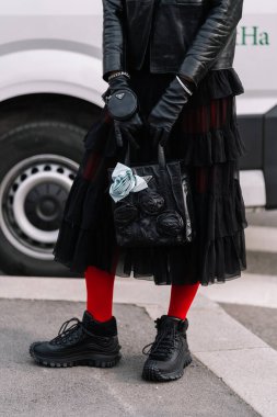 Milan, İtalya - 23 Şubat 2023: Prada Antika nappa marka deri mini çanta ve Moncler marka spor ayakkabı giyen kadın. Moda blogcusu kıyafet detayları, sokak tarzı