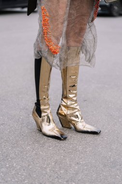 Milan, İtalya - 23 Şubat 2023: Prada Symbole çanta giyen kadın, kırmızı Cleo çanta ve diz boyu aynalı deri çizmeler. Moda blogcusu kıyafet detayları, sokak tarzı