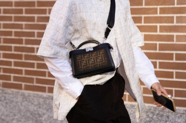 Milan, İtalya - 13 Ocak 2024: Adam Fendi Peekaboo ISeeU XCross marka çanta giyiyor, sokak tarzı detaylar, moda kıyafeti ayrıntıları