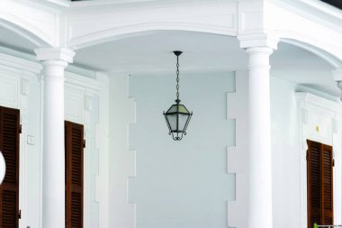 Evin çitlerinde asılı eski tarz sokak lambası. Metal çerçeveli kolye lambası