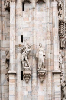Milan, İtalya - 30 Ağustos 2022: Milan Duomo Katedrali üzerindeki Gotik mermer heykeller, dekorasyon heykelleri. İtalya 'nın en büyük kilisesi ve popüler turizm merkezi..