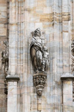 Milan, İtalya - 30 Ağustos 2022: Milan Duomo Katedrali üzerindeki Gotik mermer heykeller, dekorasyon heykelleri. İtalya 'nın en büyük kilisesi ve popüler turizm merkezi..