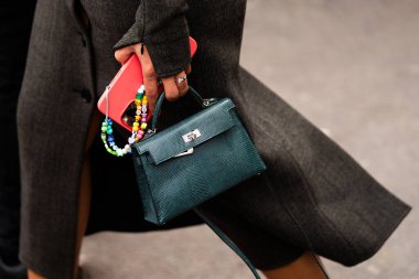 Paris, France - February, 29, 2024: woman wears Hermes Kelly bag, fashion blogger outfit details, street style. clipart
