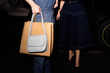 Milan, İtalya - 24 Şubat 2024: Adam Bottega Veneta çanta giyiyor, sokak tarzı detaylar, moda kıyafeti ayrıntıları