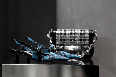 Milan, İtalya - 25 Şubat 2023: Jimmy Choo çantası ve yüksek topuklu ayakkabılar podyum vitrininde, kadın aksesuarlar mağazada sergileniyor
