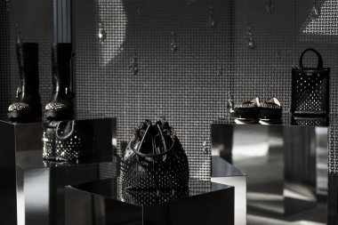 Milan, Italy - February, 25, 2023: Jimmy Choo bag and high heels on podium showcase, woman accessories in the store display clipart