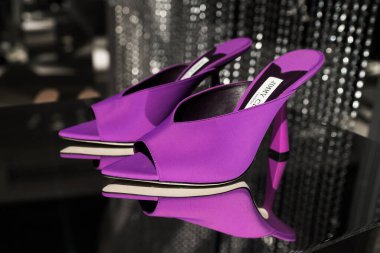Milan, Italy - February, 25, 2023: Jimmy Choo high heels on podium showcase, woman accessories in the store display. clipart