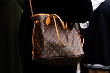 Milan, İtalya - 25 Şubat 2024: Kadın Louis Vuitton marka çanta giyer, moda blogcusu kıyafeti ayrıntıları, sokak tarzı