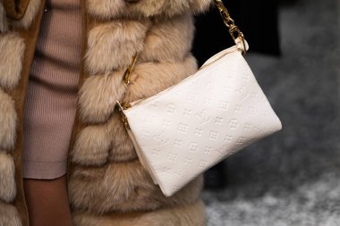 Milan, İtalya - 10 Ocak 2024: Kadın Louis Vuitton marka çanta giyer, moda blogcusu kıyafeti ayrıntıları, sokak tarzı.