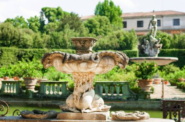 Floransa, İtalya - 30 Ağustos 2022: Boboli Bahçeleri 'ndeki efsanevi figürlerle süslü çeşme sakin gölete bakıyor