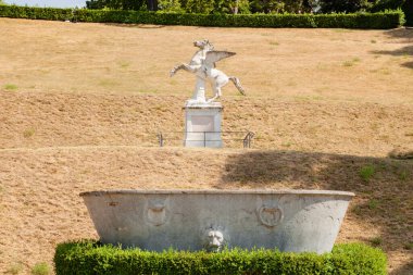 Florence, Italy - August, 30, 2022: statue of pegasus on hilltop in Boboli Gardens, Florence, with fountain in foreground clipart