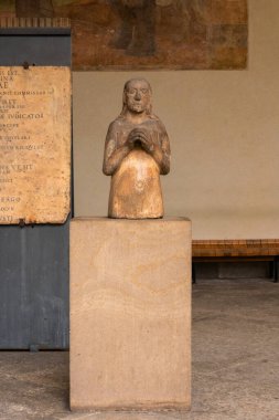Milan, İtalya - 30 Ağustos 2022: Eski bir belgeye karşı dizlerinin üzerinde dua eden figür heykeli