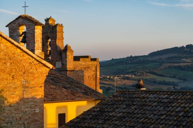 Gradara, İtalya - 25 Ağustos 2022: Gradara çatılarının ve çevresindeki kırsal alanların gün batımı manzarası