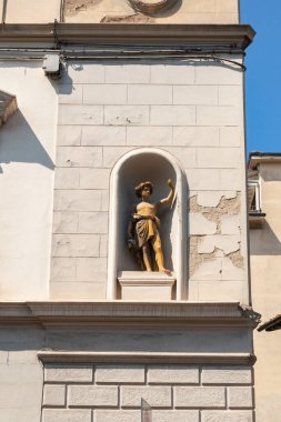 Tarihi binanın ön cephesinde yıpranmış heykel ve soyulmuş boya.