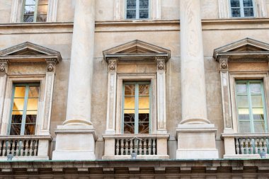 Uzun sütunlu ve dekoratif pencereli klasik bina cephesinin ayrıntılı görünümü