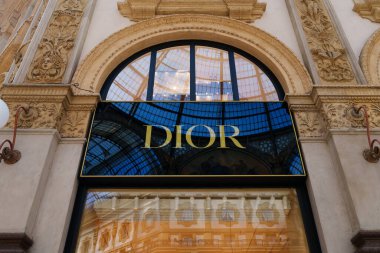 Milan, İtalya - 24.04.2024: Kadın giyim mağazasının vitrini olan Galleria Vittorio Emanuele, Milano 'nun merkezindeki alışveriş galerisinde bulunan Dior mağazası vitrini