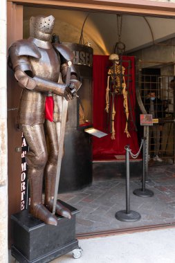 San Gimignano, İtalya - 01.05.2021: Kafeste ortaçağ zırhı ve iskeleti bulunan müze girişi, tarihi işkence aletleri sergileniyor