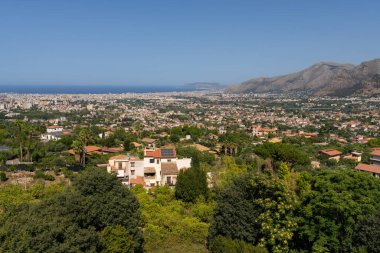 İtalya 'da Palermo' nun genişleyen şehir manzarasının panoramik manzarası dağlarla çevrili ve yemyeşil, açık mavi gökyüzü ve arka planda uzak okyanusla dolu