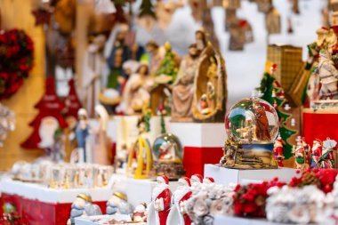 Kar kürelerinin, doğum sahnelerinin ve Noel pazarındaki diğer bayram süslerinin şenlikli gösterisi. Renkli dekorasyonlar geleneksel tatil atmosferini çağrıştırıyor. Kutlama ve neşe dolu.