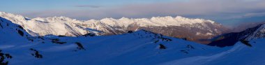 Passo Tonale yakınlarındaki dağların panoramik manzarası, Ponte di Legno, İtalya. Gri bulutlu gökyüzünün altında büyük karlı dağ sıraları. Güneşli bir günde kayak merkezi manzarası. Dağ kayak merkezi. Kar yamacı