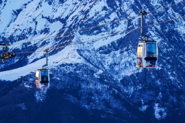 Piani di Bobbio, İtalya - 24.12.2022: Karla kaplı dağların üzerinden geçen iki teleferik, Alp manzarası ve sakin kış manzarası