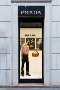 Milan, İtalya - 24.04.2024: Şık moda Prada vitrininde tasarımcı kıyafetleri ve lüks perakende için aksesuarlar yer alıyor.