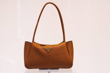 Milan, İtalya - 24.04.2024: Moda aksesuarları ve lüks tarzı için altın kaplamalı zarif kahverengi Prada çanta.