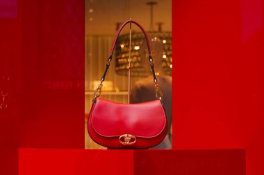 Milan, İtalya - 24.04.2024: Lüks mağazalarda sergilenen şık kırmızı Valentino el çantası.