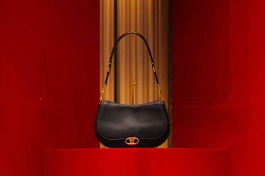 Milan, İtalya - 24.04.2024: Zarif siyah Valentino el çantası lüks kırmızı ayarı sergileniyor.