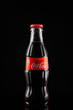 Milan, İtalya - 09.01.2022: Reklam veya marka tanıtımı için siyah zemin üzerine klasik Coca Cola şişesi.