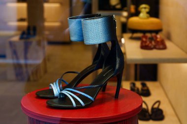 Milan, İtalya - 24.04.2024: Zarif mavi aksanlı Ferragamo yüksek topuklu sandaletler mağazada sergileniyor.