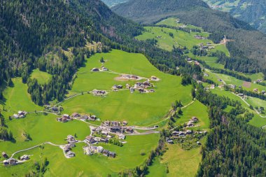 İtalya 'nın Dolomites kentindeki Funes Vadisi yakınlarındaki yemyeşil tepelerle çevrili cennet gibi bir alp köyünün manzarası..