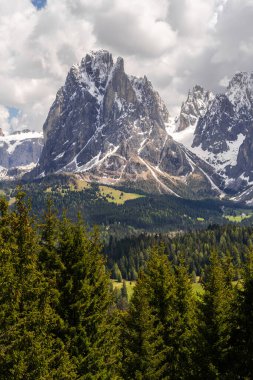 İtalya 'nın Dolomitler şehrinde Funes Vadisi yakınlarında karlı tepeleri ve yemyeşil ormanları olan görkemli dağ manzarası..