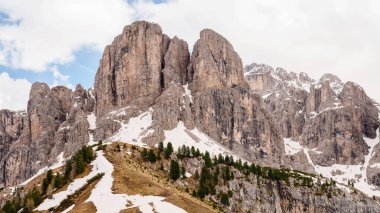 İtalya 'nın Dolomites kentindeki Funes Vadisi yakınlarında kar ve çam ağaçları ile görkemli dağ zirveleri.