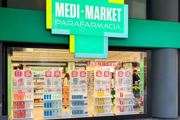 Milan, İtalya - Nisan 07, 2025: Reklam tabelaları ve cam pencereden görülebilir ürün rafları olan Medi-Market para-eczane mağazası. Ön görünüm.