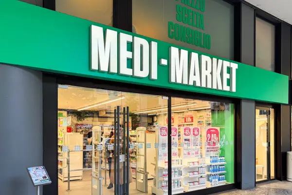 Milan, İtalya - Nisan 07, 2025: Reklam tabelaları ve cam pencereden görülebilir ürün rafları olan Medi-Market para-eczane mağazası. Ön görünüm.