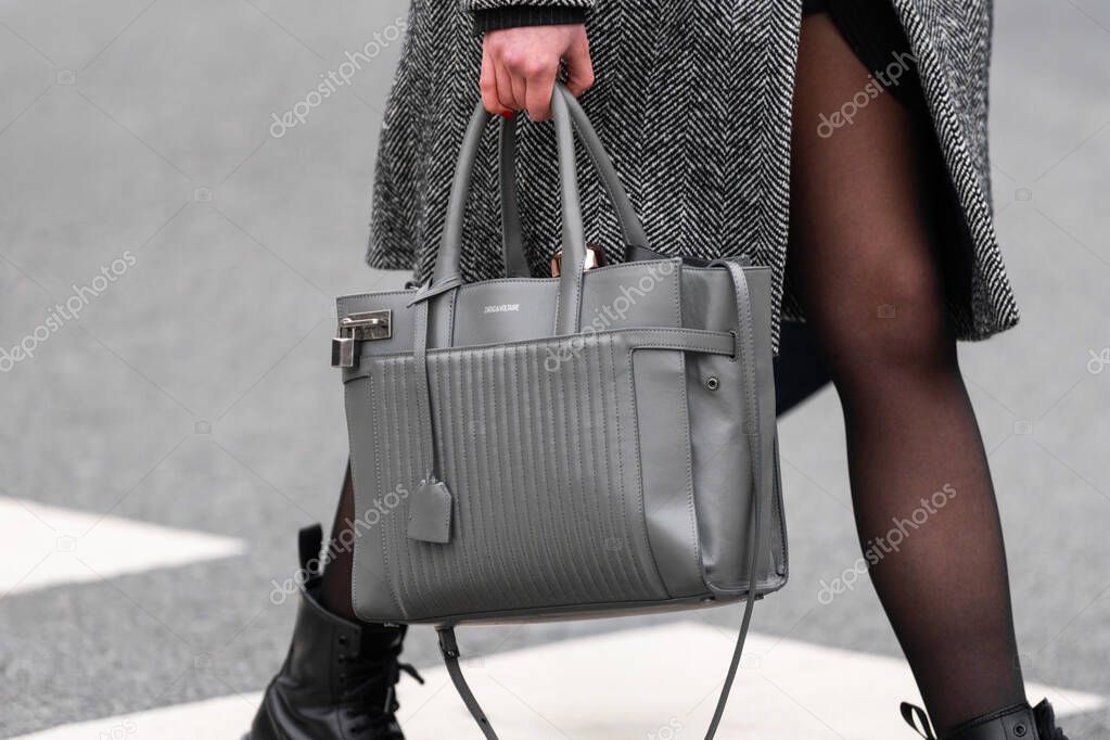 Paris, France - March 11, 2025: Close-up of a gray Zadig and Voltaire structured leather bag styled with tights and boots, street style outfit in Paris.