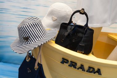 Milan, İtalya - 12 Nisan 2025: Prada penceresi. Çizgili ve logolu yaz şapkaları. Güneş gözlüklü siyah tuval. Denizcilik teması.