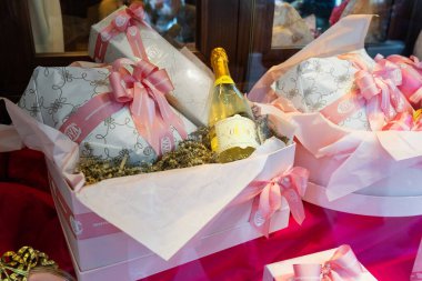 Milan, İtalya - 12 Nisan 2025: VOYA Montenapoleone. Şatafatlı Paskalya hediye kutusu, köpüklü şarap ve butik vitrininde şenlikli ambalaj. Pembe kurdele paketi...