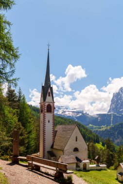 İtalya 'nın Dolomites kentindeki Funes Vadisi' nin yakınlarındaki dingin doğal güzellikleri yakalayan gür orman manzarasındaki görkemli kilise..
