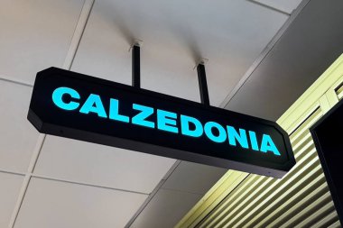 Milan, İtalya - Nisan 07, 2025: Tavandan sarkan gök mavisi ile işaretlenmiş Calzedonia. Milan Centrale alışveriş merkezinde modern markalaşma.