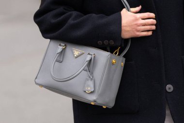 Paris, Fransa - 11 Mart 2025: Kadın gri Saffiano derili ve altın donanımlı Prada Galleria çanta giyiyor. Lüks tasarımcı aksesuarı. Şık sokak tarzı için zarif moda ayrıntıları.
