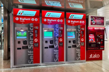 Milan, İtalya - Nisan 07, 2025: Milan Merkez İstasyonu 'ndaki Trenitalia ve Italo self-servis bilet makineleri. Hızlı tren rezervasyonları için kırmızı kiosklar.
